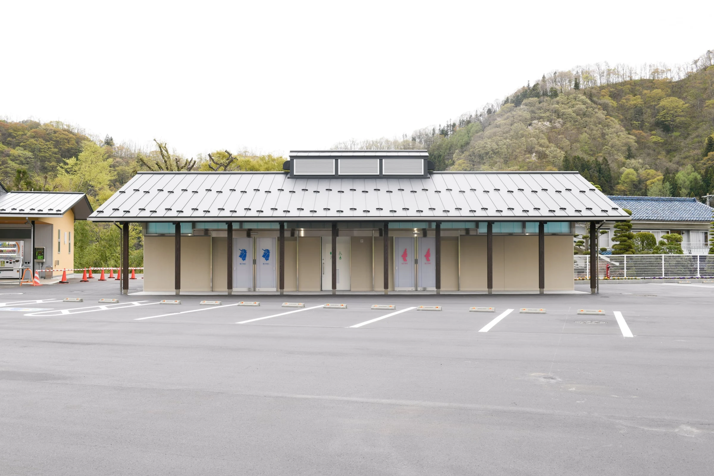 正面から見たトイレ棟。横並びの入口と、屋根の上の天窓