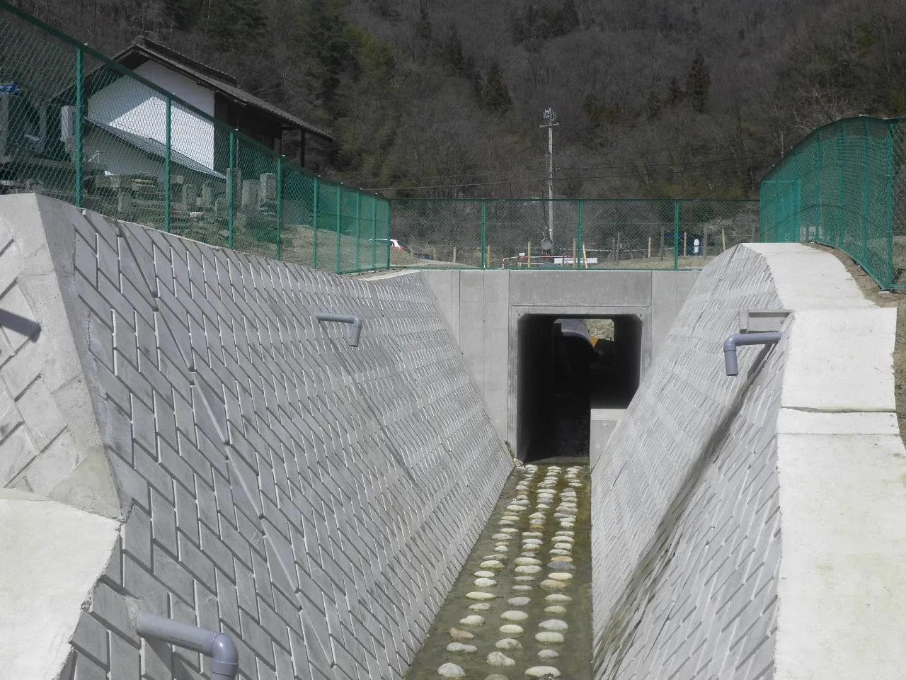 両岸をブロックで固めた水路と、その先のボックスカルバート