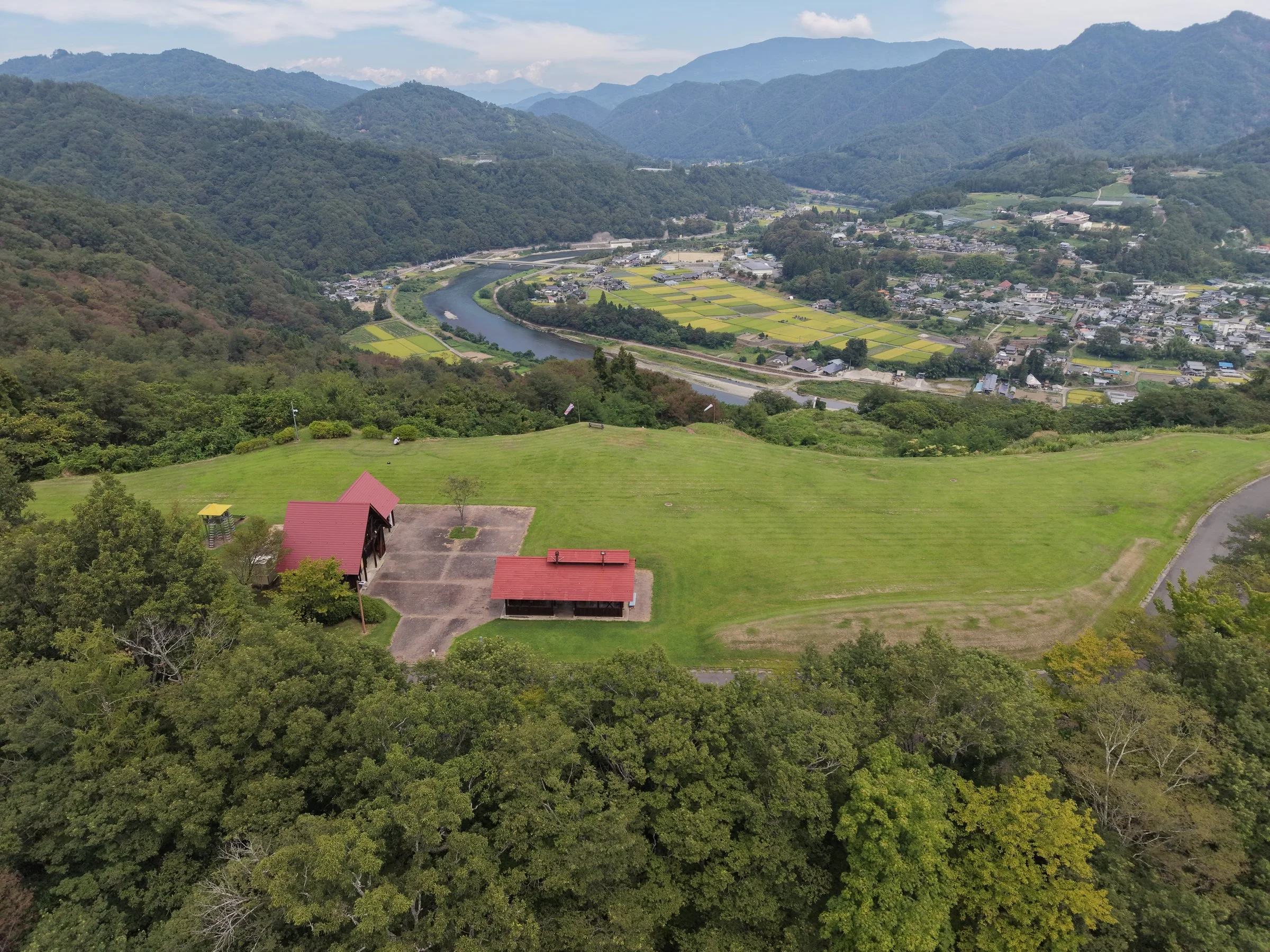 上空から見た造成地と、川沿いに広がる集落