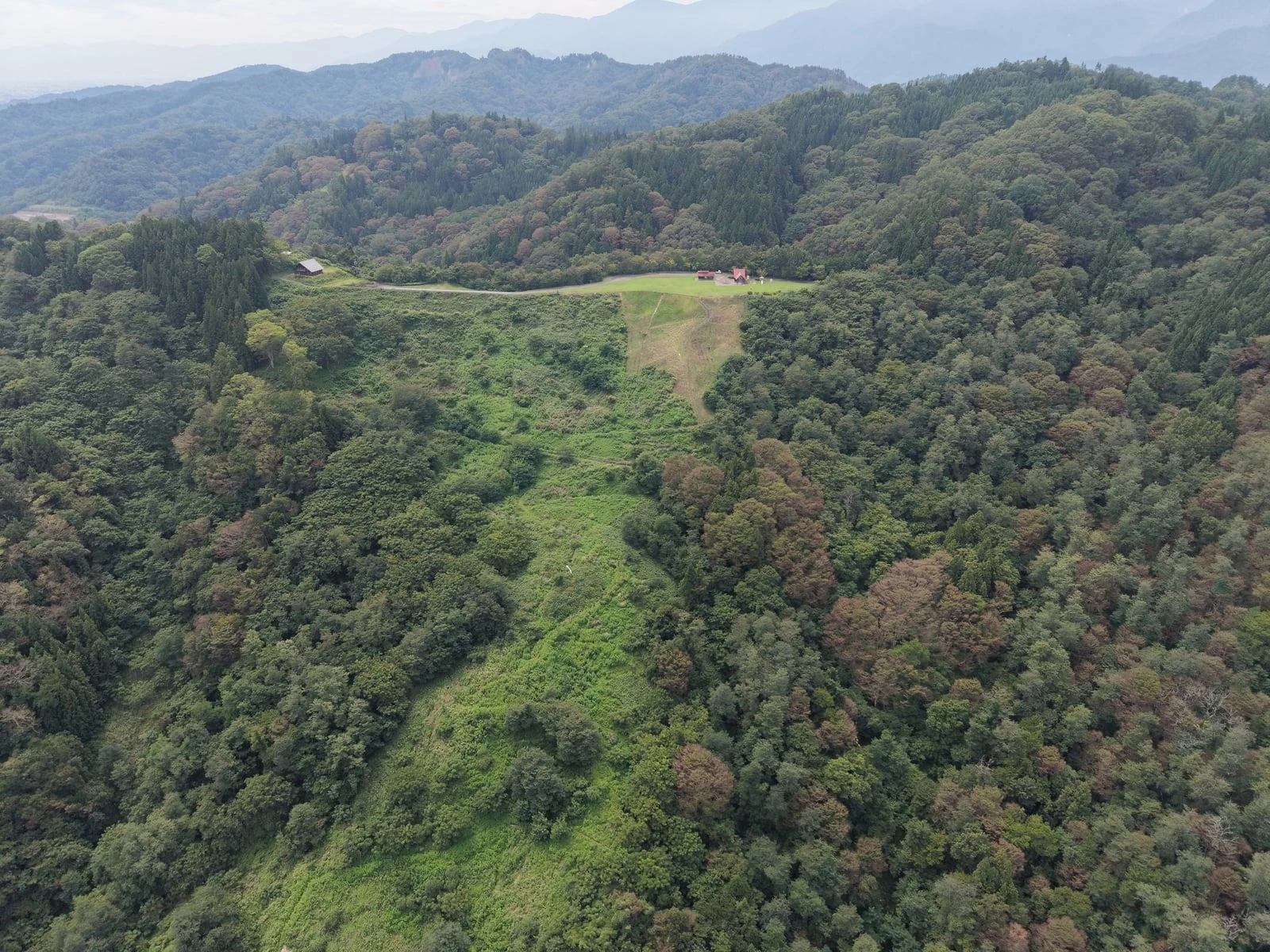 幾重にも重なる山の尾根と、その頂に切り開かれた広場