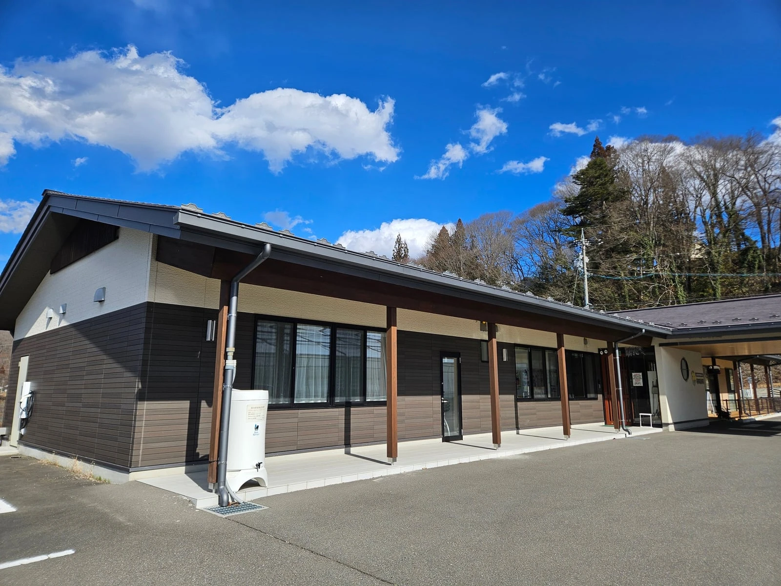 木の柱が並ぶ庇の下に窓が続く建物の側面
