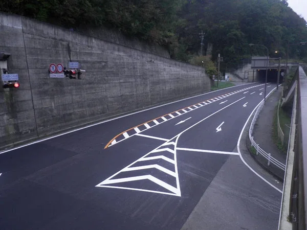 トンネル坑口の手前まで打ち替えられた舗装と引き直した区画線